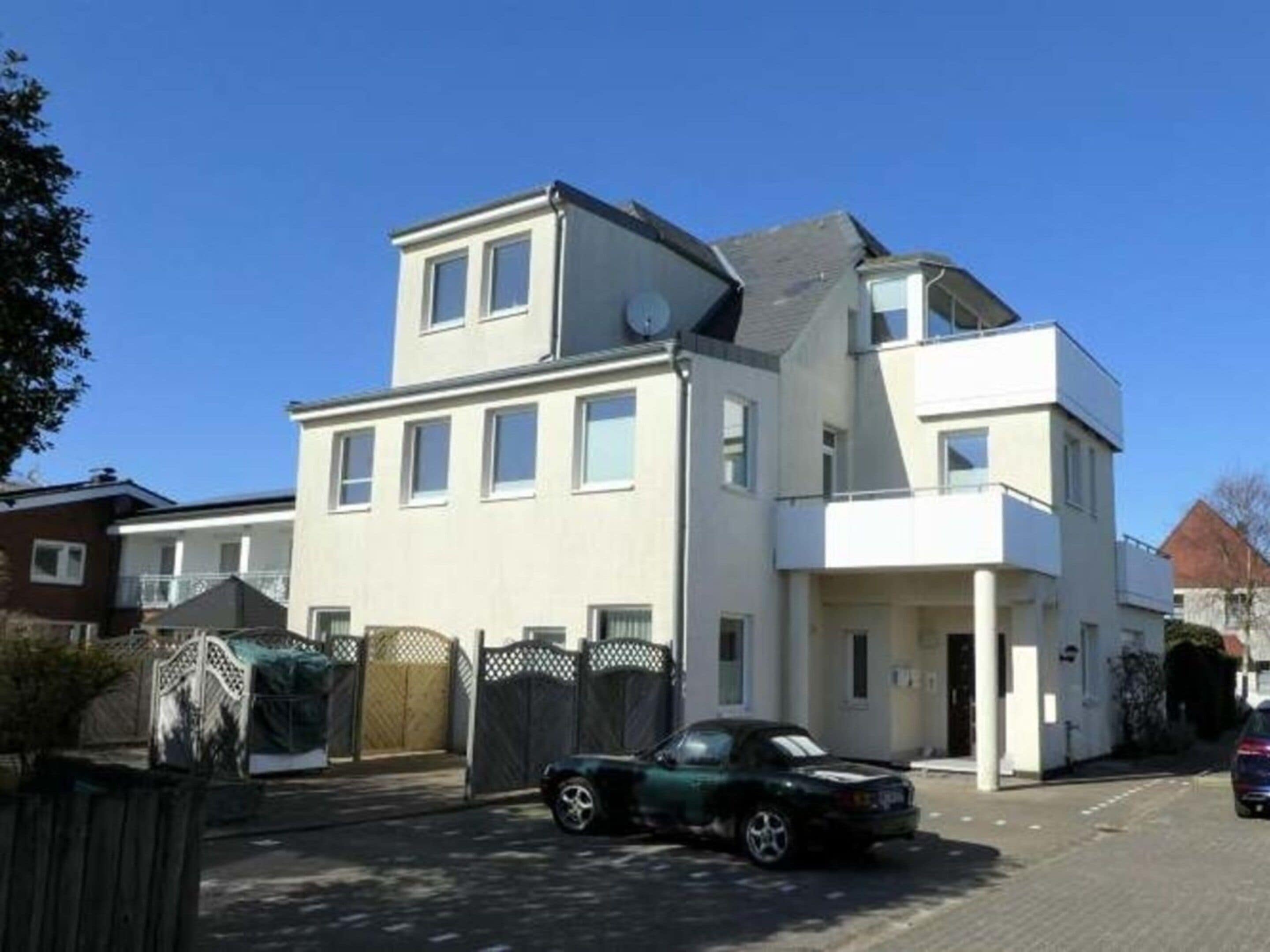 Un immeuble résidentiel de deux étages, doté d’un toit plat et d’un garage.