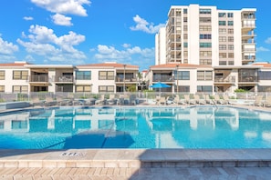 A swimming pool with lounge chairs and a no diving sign, surrounded by a white fence and a multi-story building with balconies. - Water Views/Pool - Bahia Shores O-503 - Sunrise on the Bay (St. Petersburg)