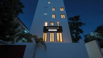 Un edificio moderno con un letrero que dice 'TOWNHOUSE' y una etiqueta que indica servicio de la empresa.