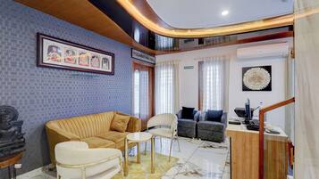 Un vestíbulo de hotel con mostrador de recepción, zona de estar y una escalera.