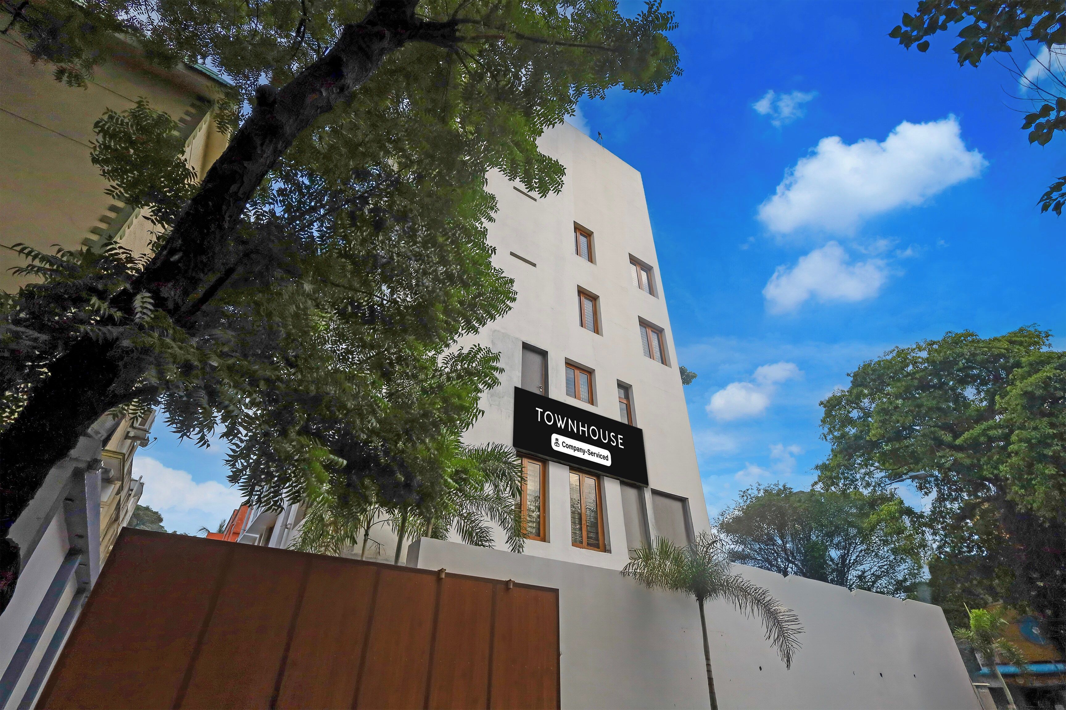A multi-story building with a sign indicating it is a company-serviced townhouse.
