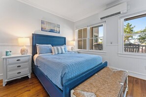 A bedroom with a bed, bedside tables, a window, and a view of the outdoors. - This enchanting handicap accessible 1st floor suite is a perfect gateway to enjo (Bald Head Island)