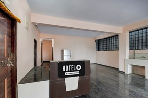 A hotel reception desk with a sign indicating it is company-serviced.