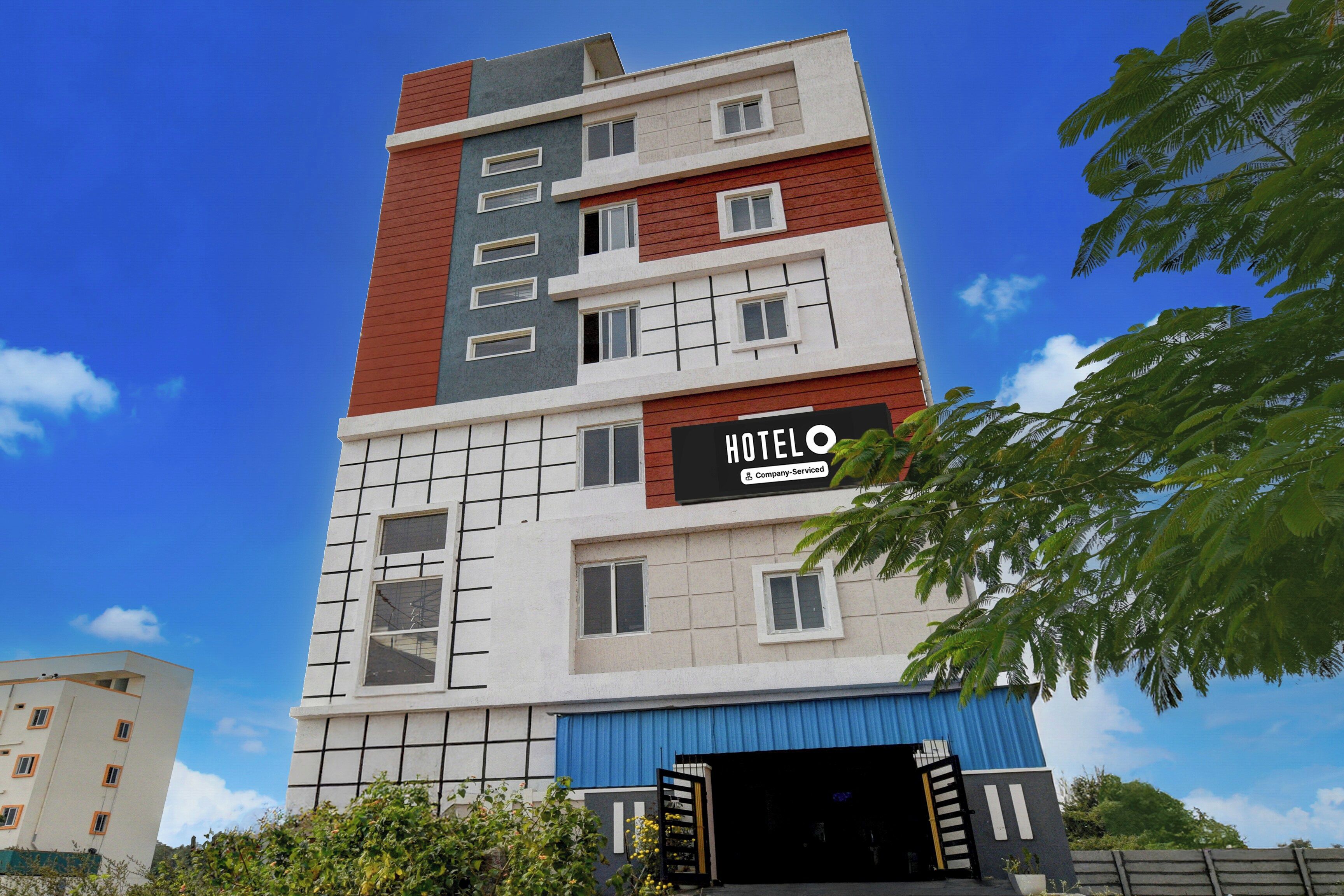 A multi-story hotel building with a sign indicating it is company-serviced.