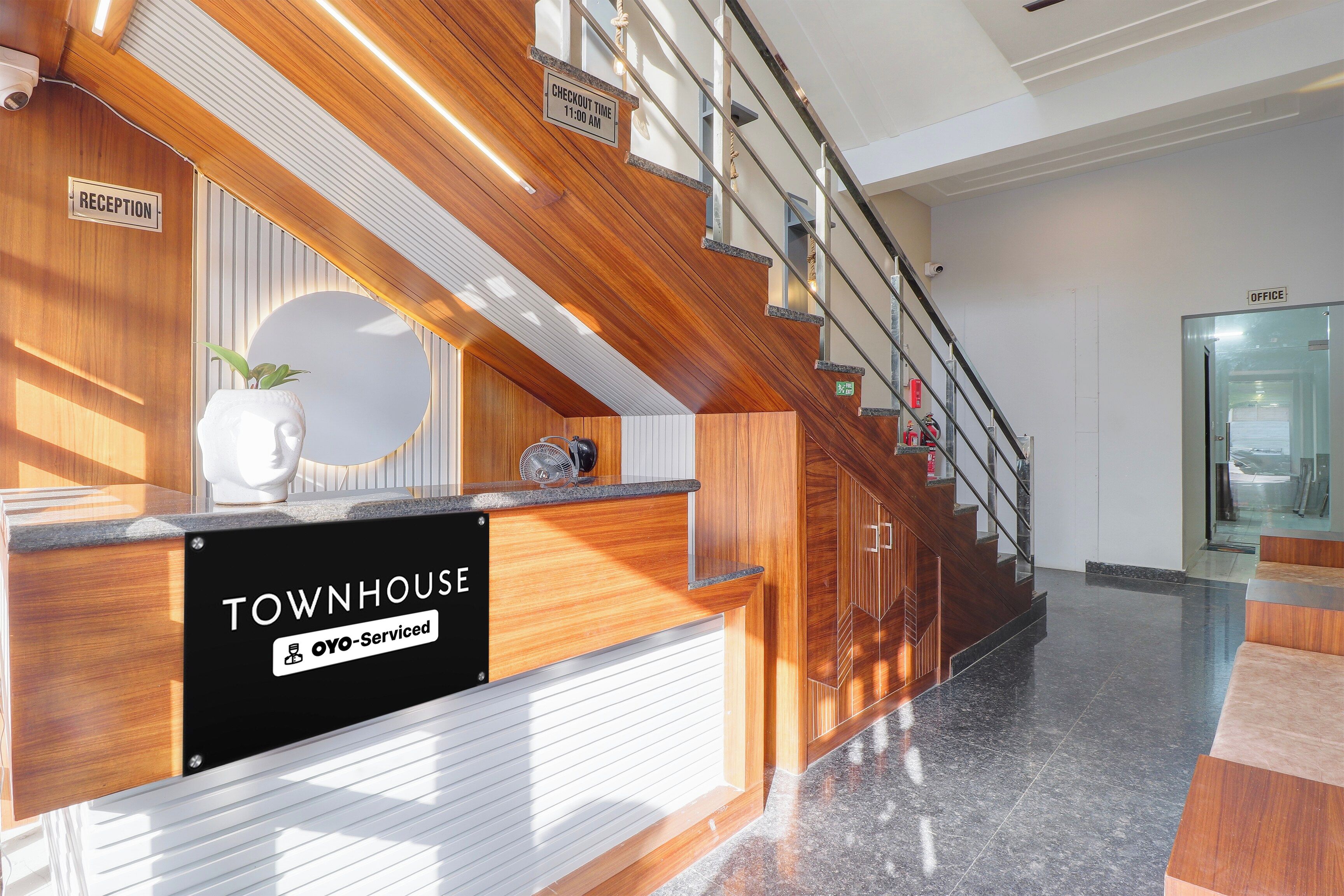 Ein Empfangsschalter mit einem Schild, das 'Townhouse' und 'Oyo-Serviced' ausweist.
