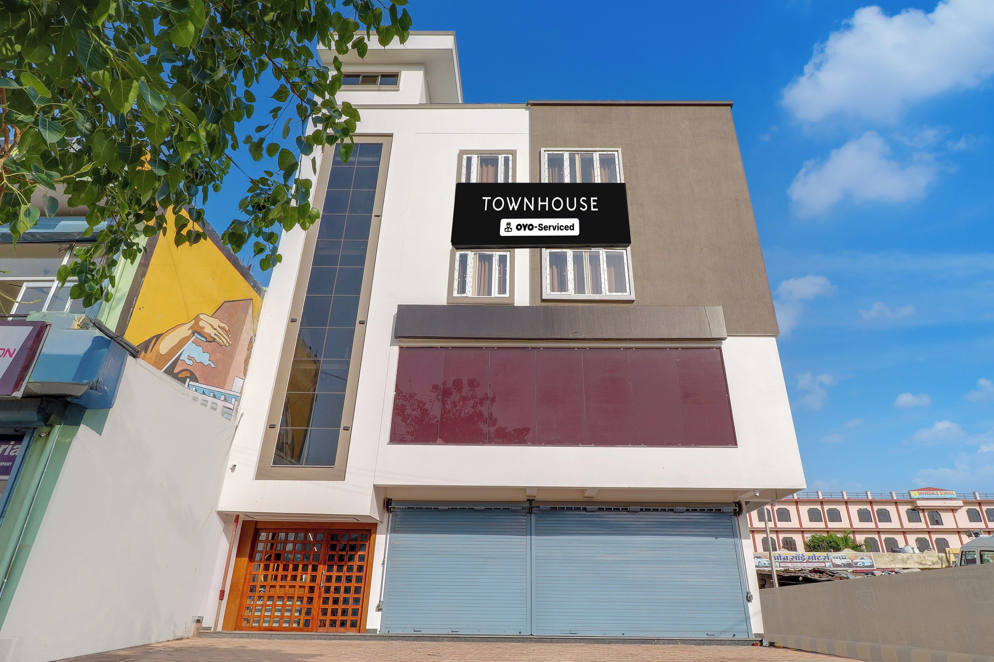 Ein modernes Reihenhaus mit Garage, einem Hinweisschild und einem Wandgemälde an der Seite.