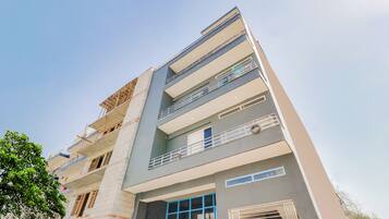 A multi-story building with balconies and a window with a blue frame.