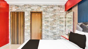 Un dormitorio moderno con una cama grande, dos puertas, una pared con textura de piedra y una pared de acento roja.