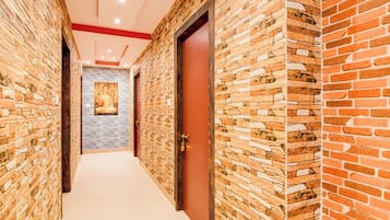 A corridor with brick walls and a white carpet.