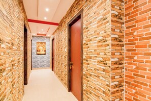 A corridor with brick walls and a white carpet.