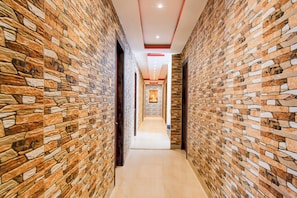 A corridor with textured stone walls and a central walkway. - OYO 834317 Love Point (Kolkata)