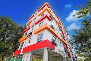 A multi-story building with a distinctive color pattern of red, white, and orange.
