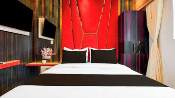 A modern hotel room with a large bed, a TV, a wardrobe, and a mirror.