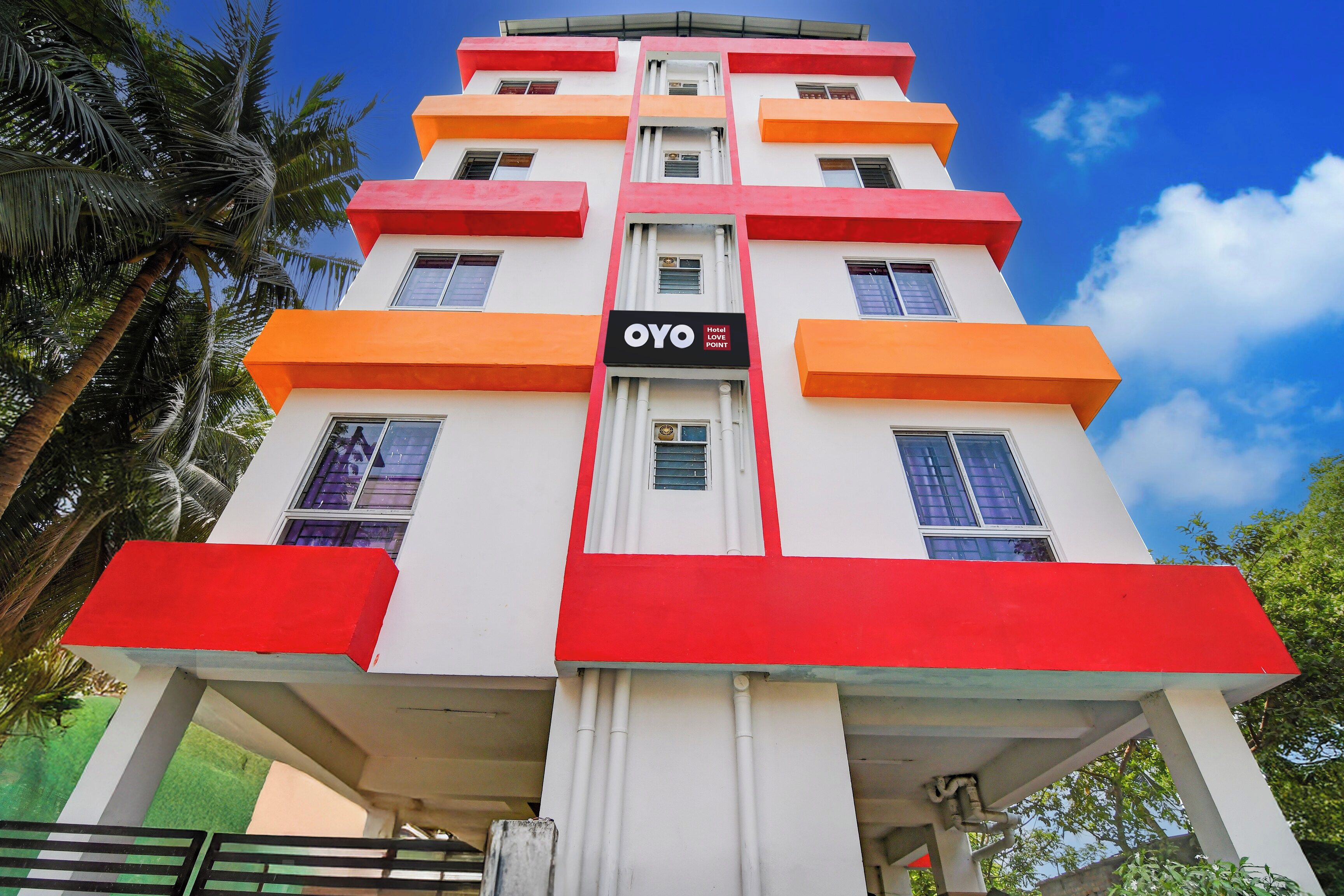 Un hôtel à plusieurs étages, reconnaissable à son grand panneau indiquant « OYO Hotel Love Point ».