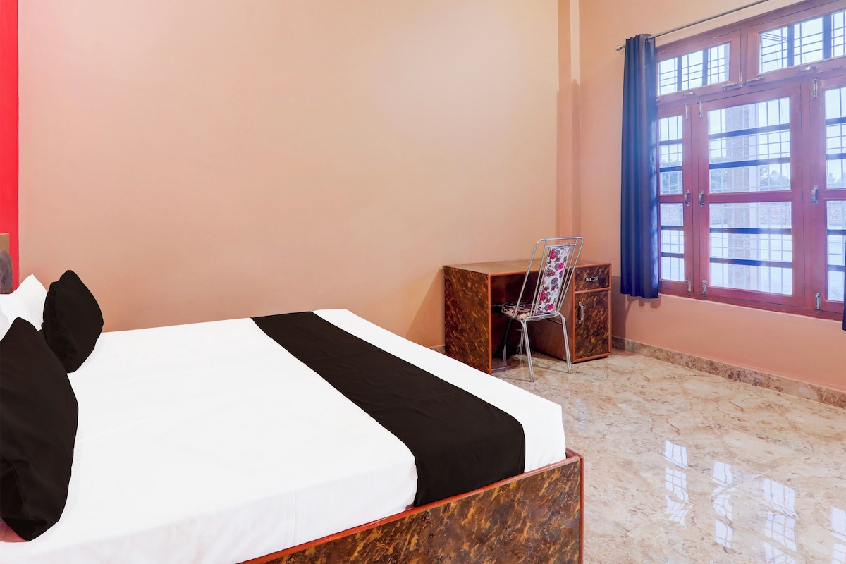 A hotel room with a bed, a desk, and a chair.