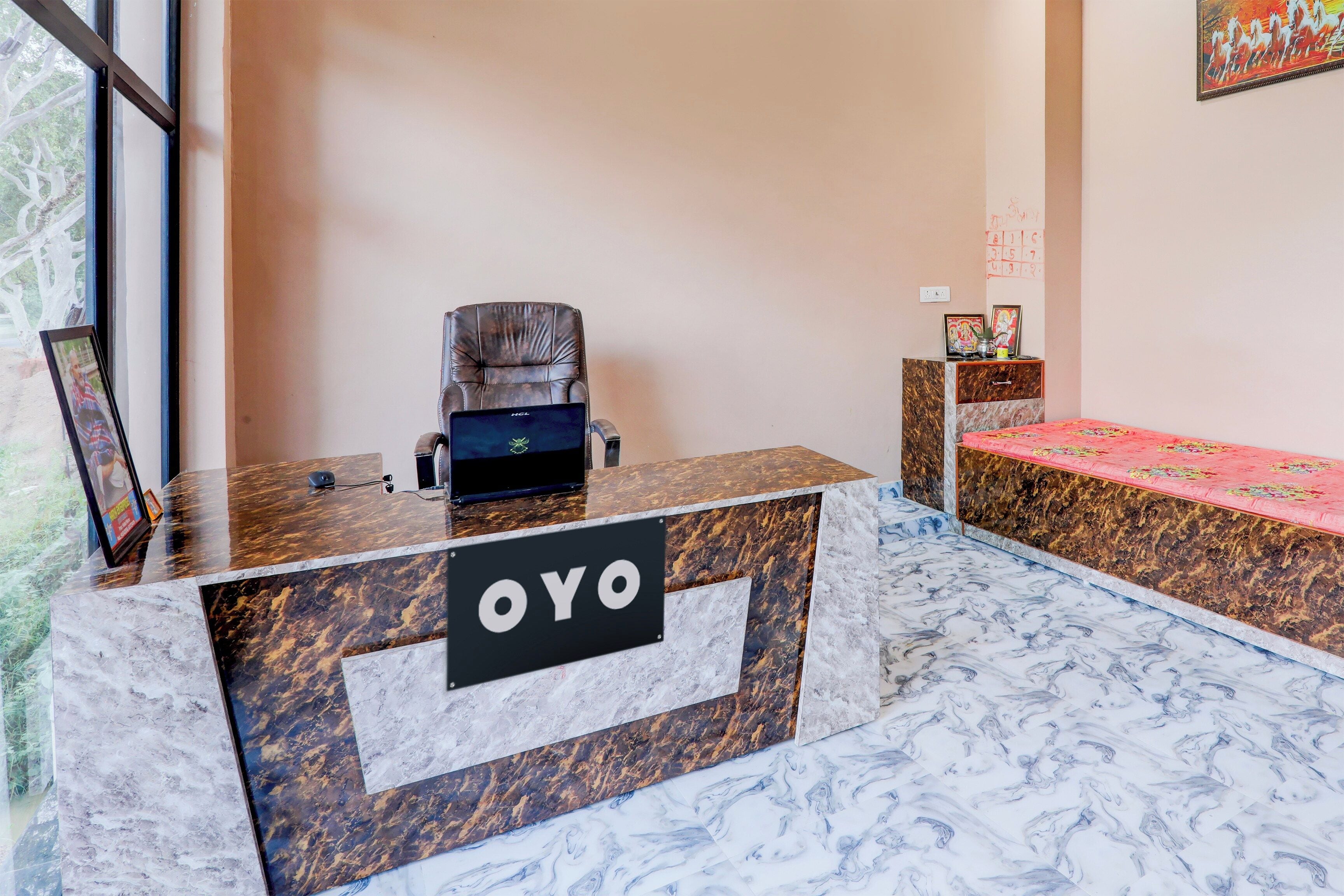 A reception desk with a marble top and a sign that reads 'OYO'.