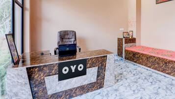 A reception desk with a marble top and a sign that reads 'OYO'.