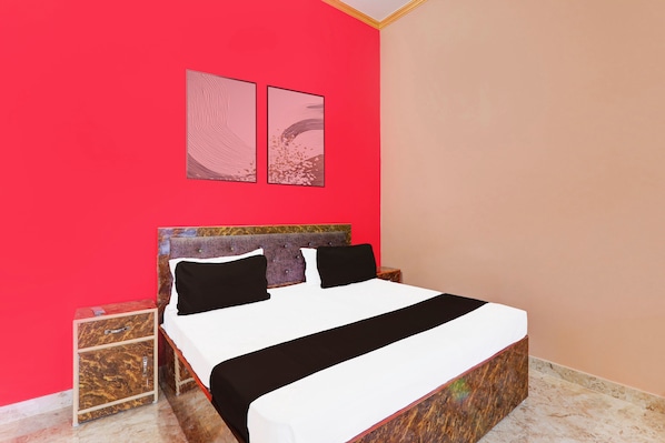 A bed with a headboard, two pillows, and a bedside table with a drawer.