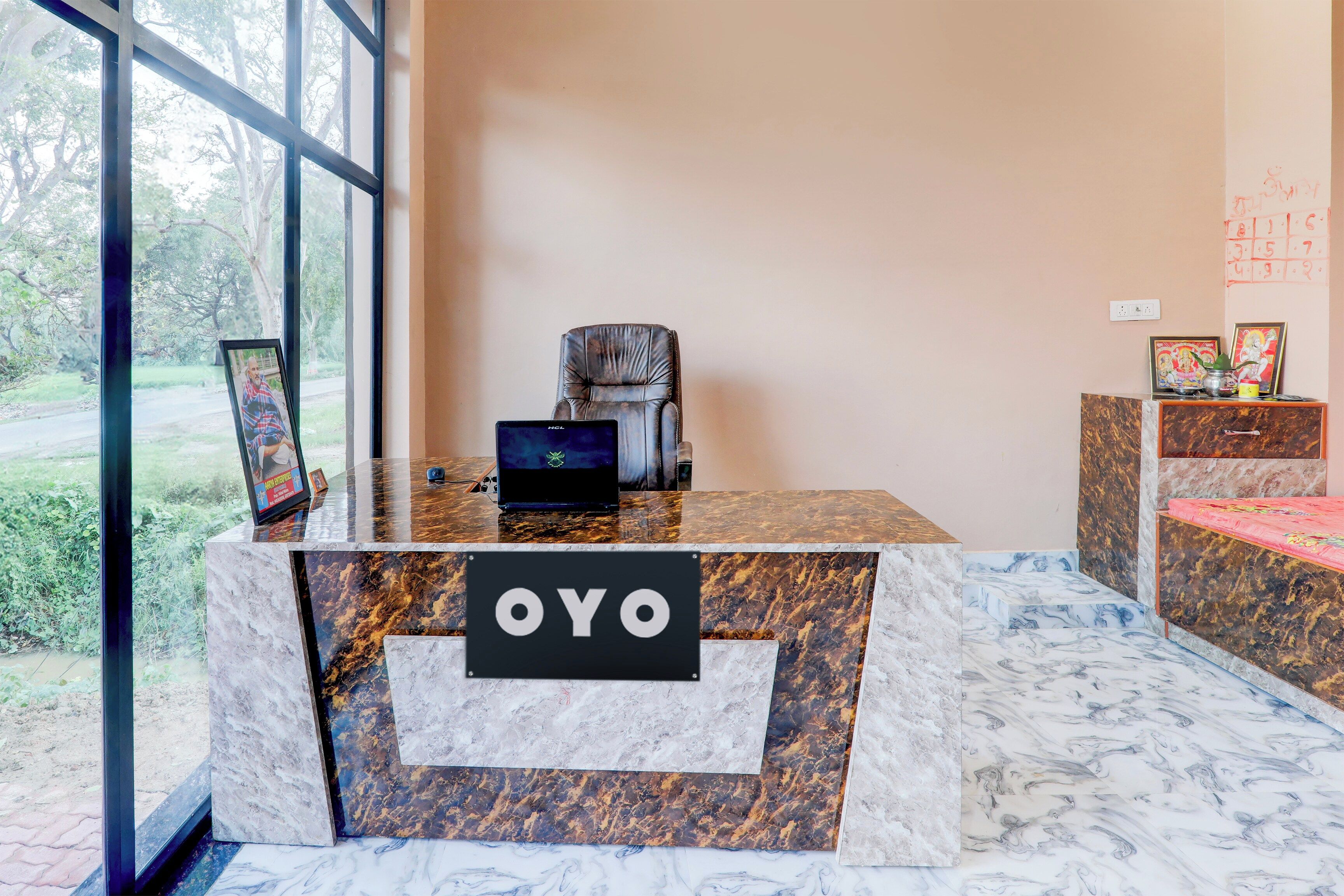 Una recepción con encimera de mármol, un cuadro enmarcado y un cartel que dice 'OYO'.