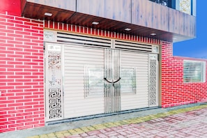 A building with a red brick facade and a large, ornate metal gate.