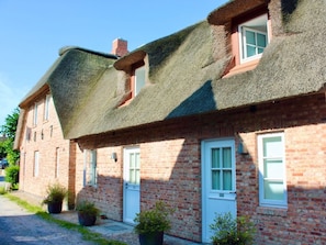 A row of brick houses with thatched roofs and white-framed windows. - 3 Barbados in the Boldix House (Wyk auf Foehr)