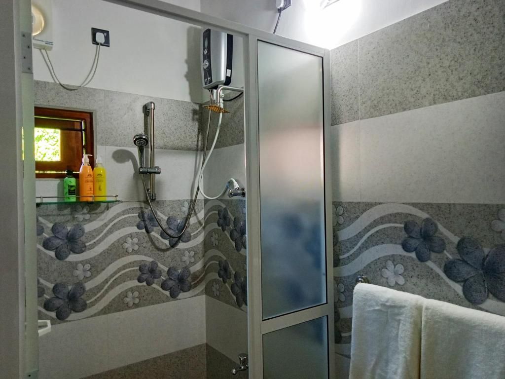 A bathroom with a shower enclosure, a towel rack, and a mirror.