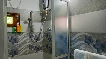 A bathroom with a shower enclosure, a towel rack, and a mirror.