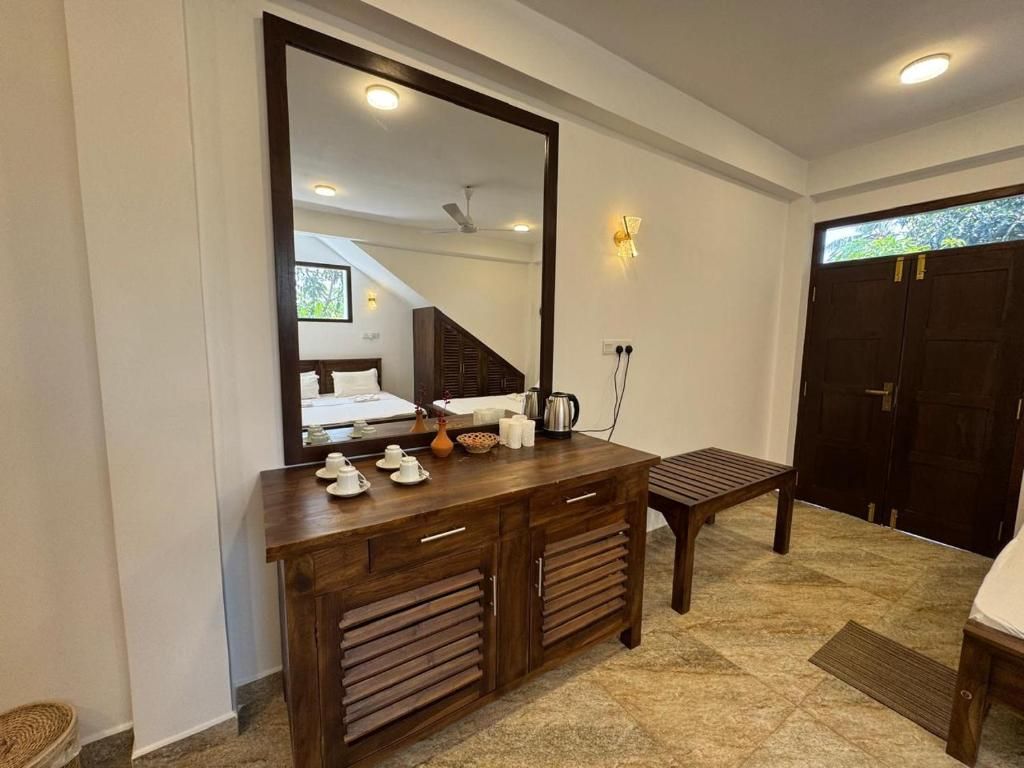 Un dormitorio con un espejo grande, muebles de madera, una cama y vistas al exterior.