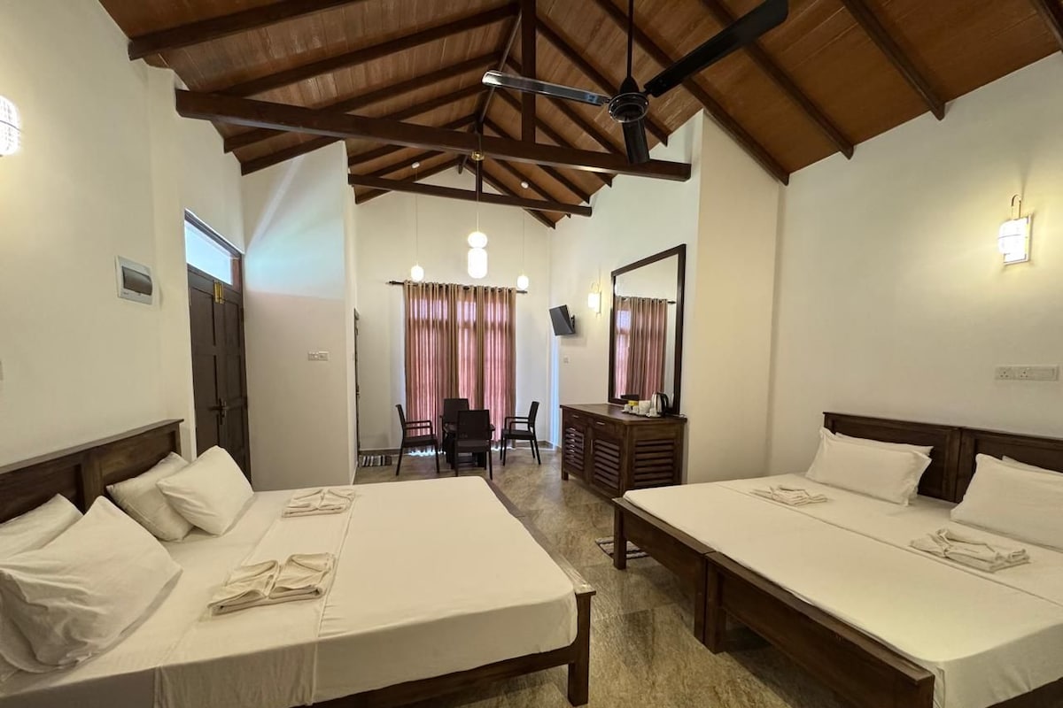 Une chambre d’hôtel avec deux lits, un bureau, une chaise et un miroir.