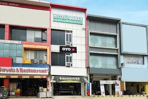 A multi-story building with a sign for Hotel Galaxy, a makeup salon, and a bank. - Hotel O Galaxy (Faridabad)