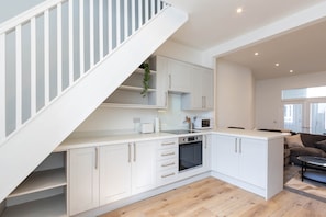 A modern kitchen with white cabinetry, a built-in oven, and a microwave. - Cosy 3 Bed | Sleeps 7 | Free Parking (Bristol City)