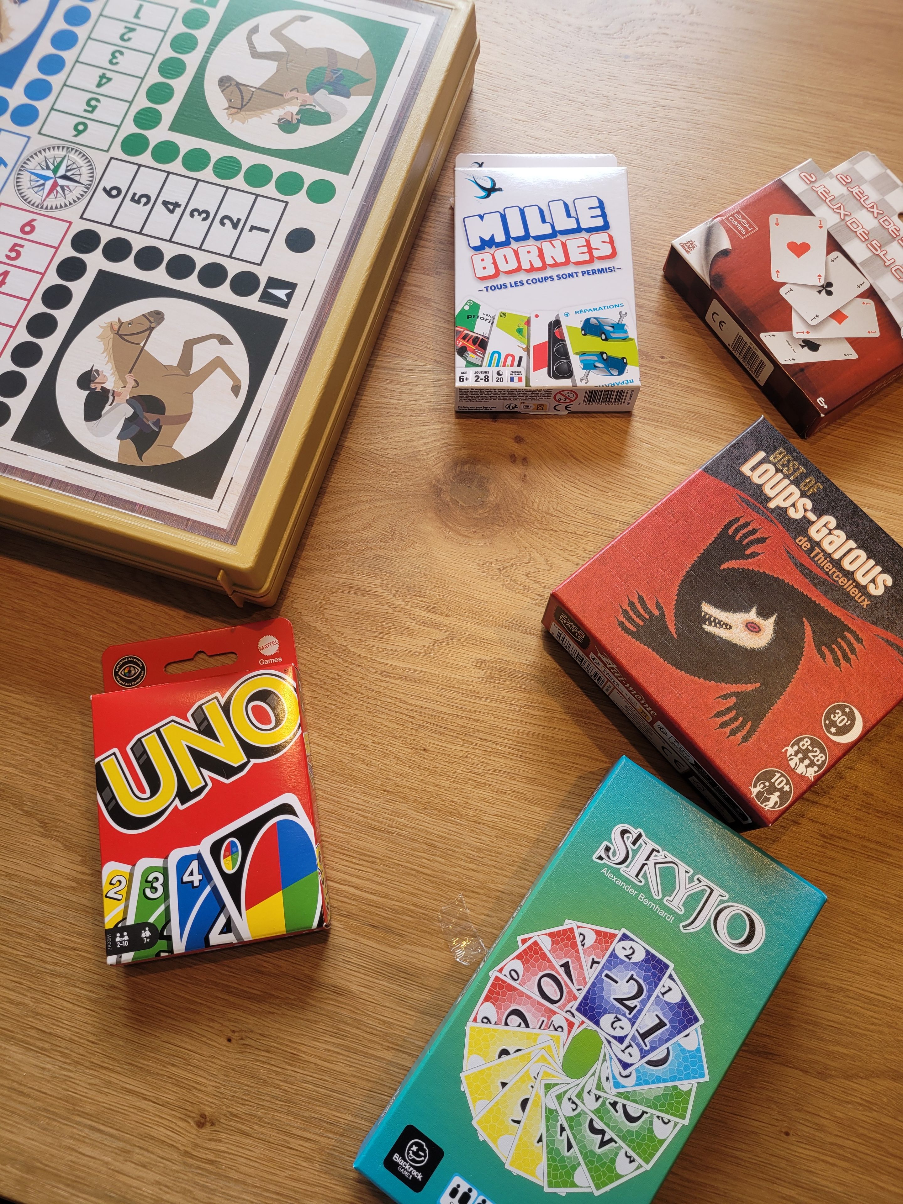 A wooden table with various board games and game boxes.