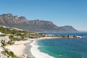 A coastal town with a beach, buildings, and mountains in the background. - Clifton 2 Bed Apartment Ocean Views Dunmore Noir (Cape Town)