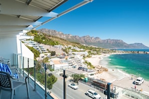 A coastal town with a view of the ocean and mountains, featuring modern buildings and a clear sky. - Clifton 2 Bed Apartment Ocean Views Dunmore Noir (Cape Town)