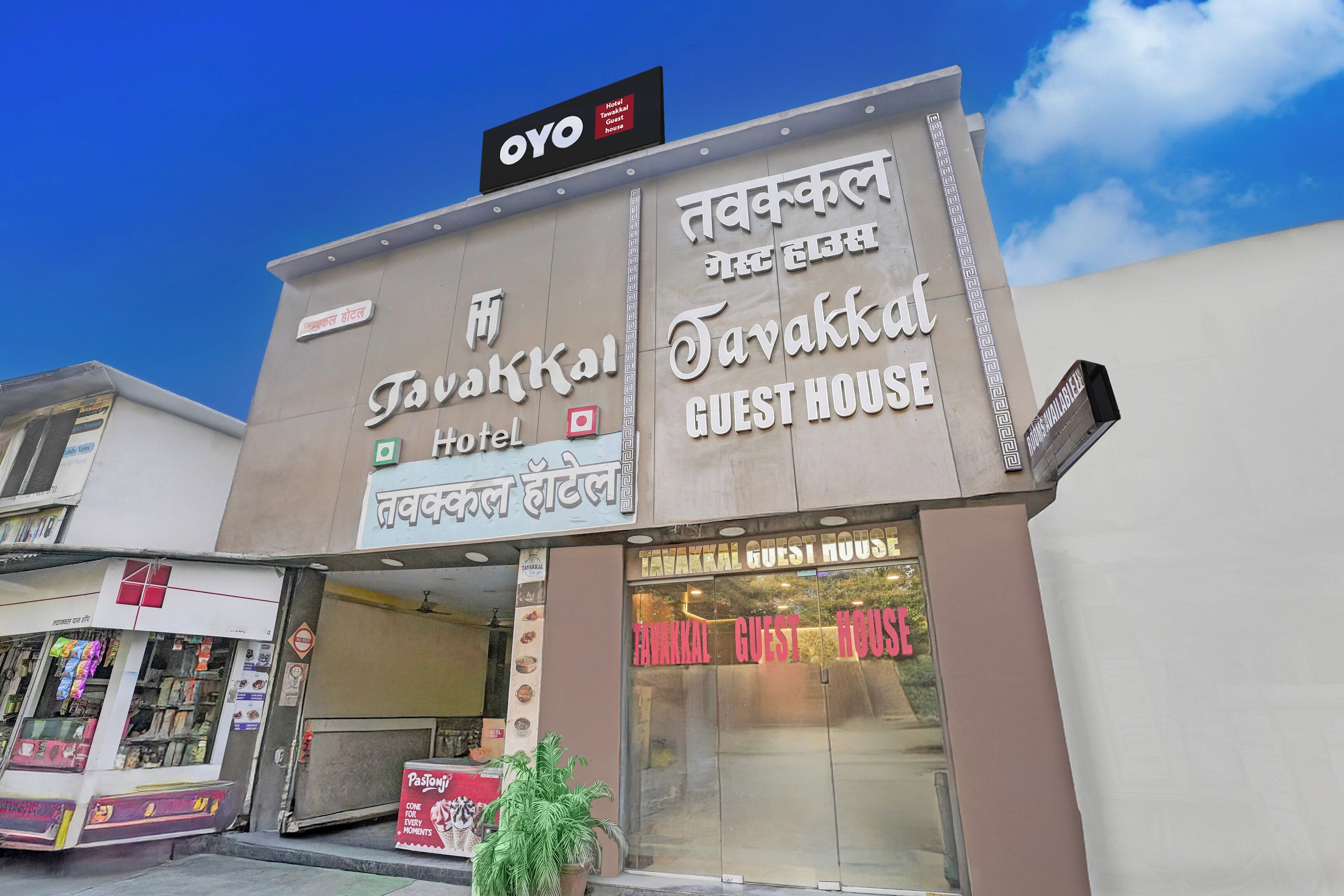 A building with signs for 'Tavakkal Hotel' and 'Tavakkal Guest House' in both English and another language.