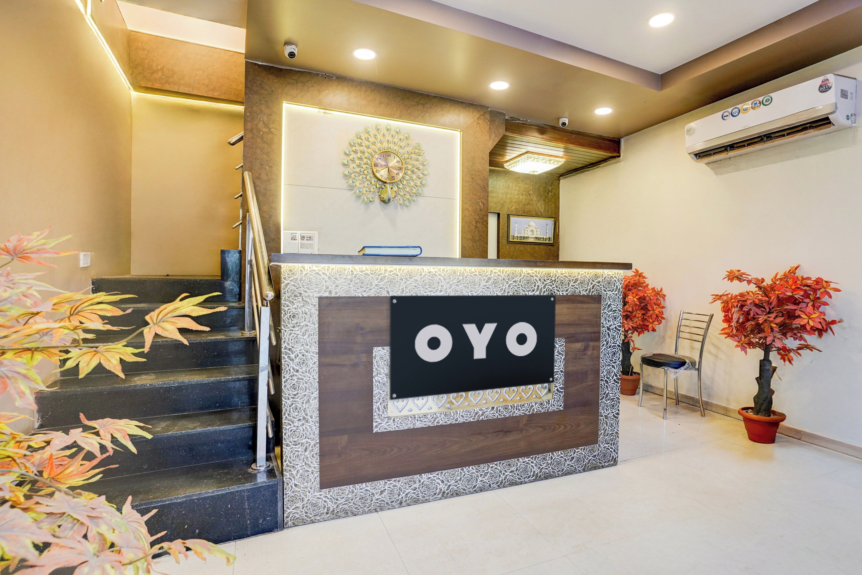 Una mesa de recepción con un cartel que dice 'OYO' y un reloj encima.