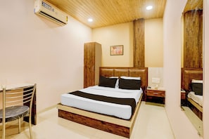 Quarto de hotel com cama, mesa de cabeceira e ar condicionado.