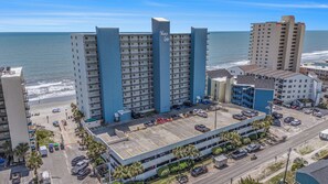A multi-story hotel with a parking lot and beach view. - Oceanfront 2bed/2bath-Water's Edge Resort-211 Indoor/Outdoor Pool & Hot Tub (Murrells Inlet)