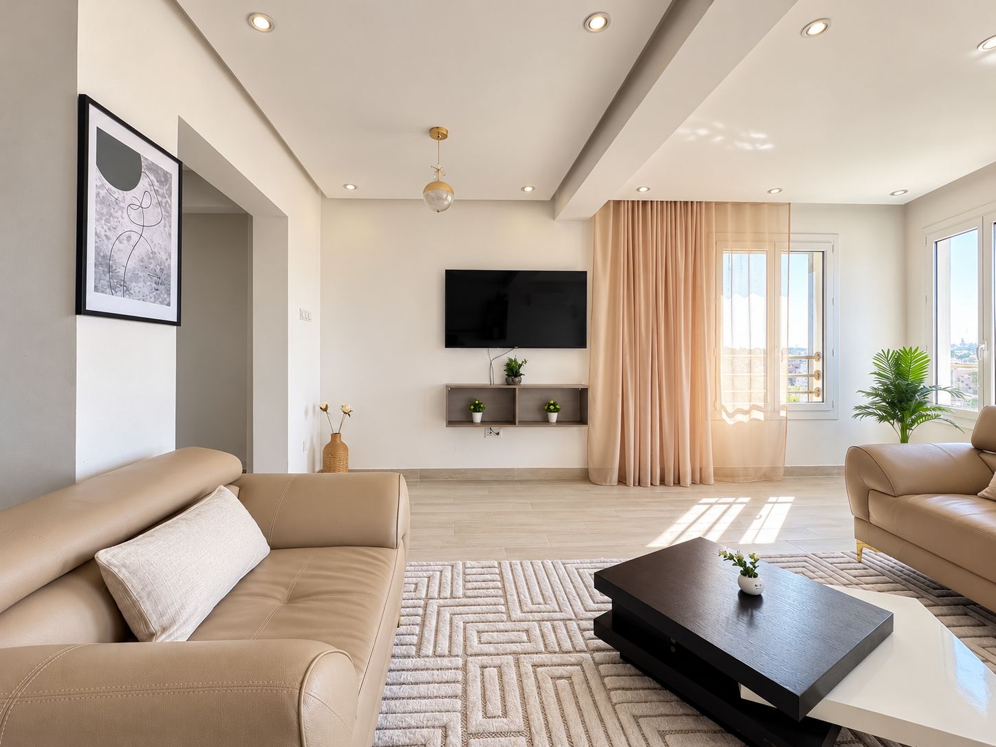 A modern living room with a sofa, a coffee table, a TV, and a window with curtains.