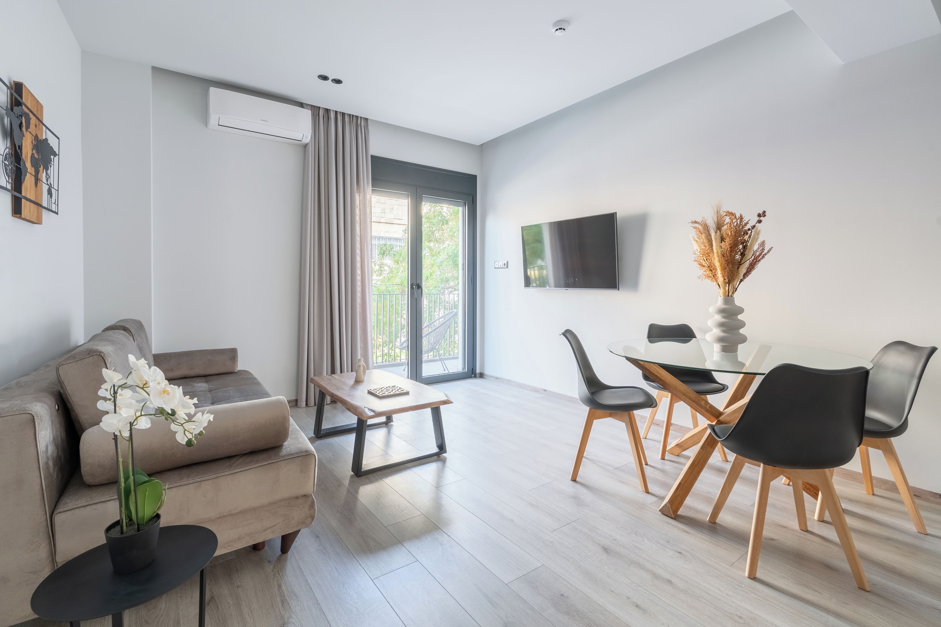 Un salon moderne comprenant un canapé, une table basse et un coin repas avec des chaises et une table.