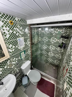Ein Badezimmer mit Toilette, Waschbecken und Duschbereich.