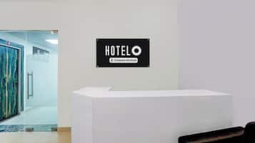 Una recepción de hotel con un cartel que indica servicio de empresa.