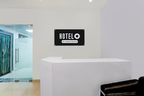 A hotel reception desk with a sign indicating it is company-serviced. - Super Hotel O Greater Noida West Link (Greater Noida)