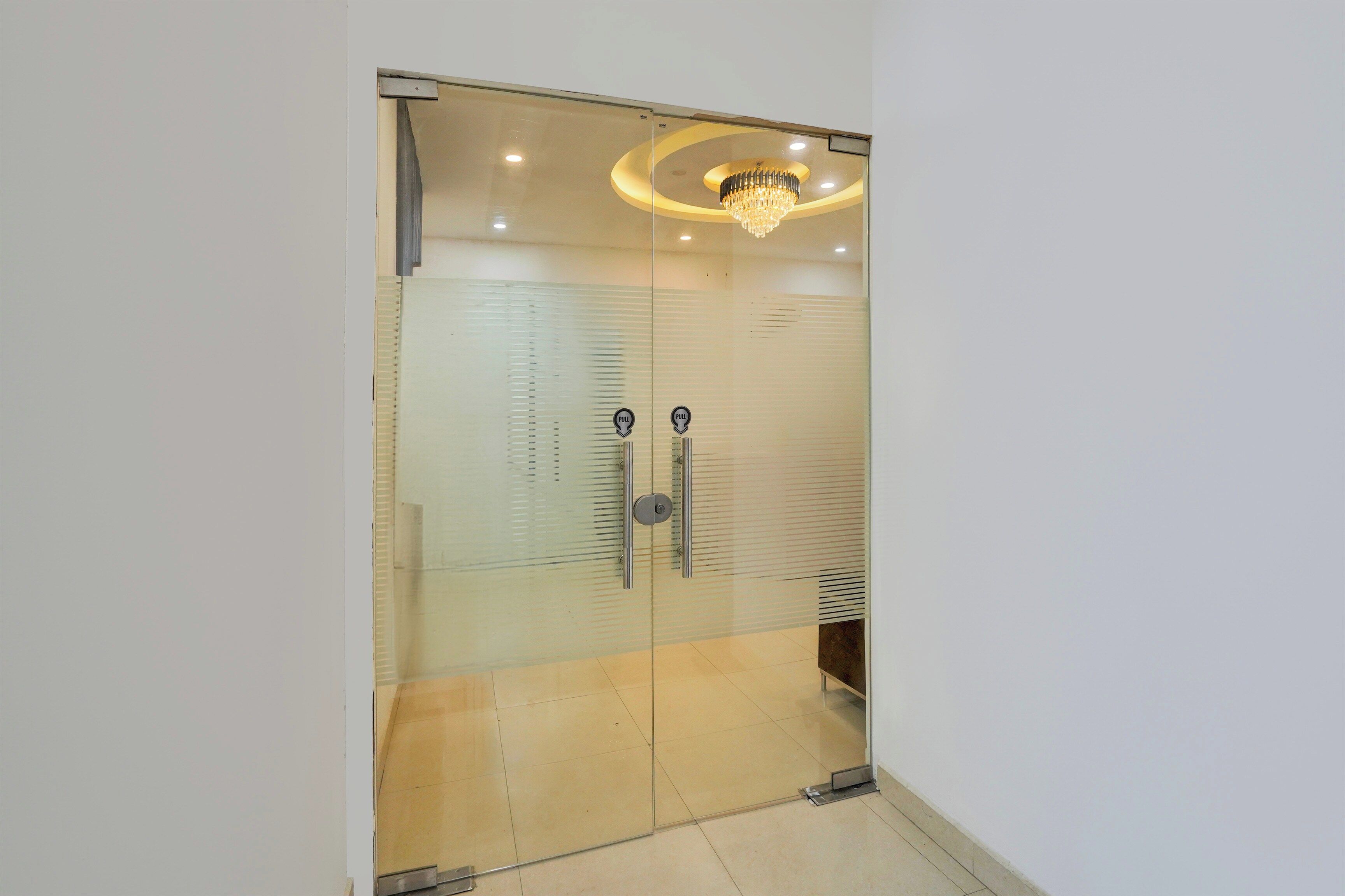 A room with a glass door, a chandelier, and a pull handle.