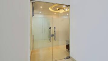A room with a glass door, a chandelier, and a pull handle.