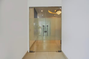 Un interior moderno con una puerta de vidrio esmerilado, un tirador y una lámpara de araña.