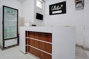 Una recepción con diseño de panel de madera, una vitrina con una bandera y un letrero que dice 'Collection oyo-Serviced'.