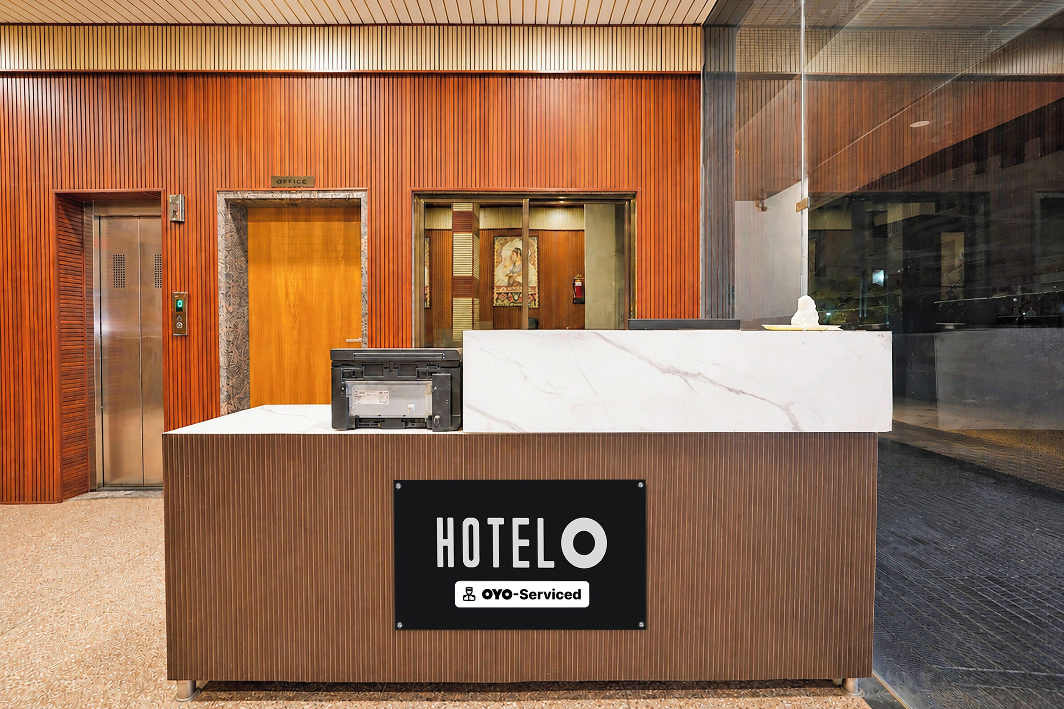 Ein Hotelrezeptionstisch mit einem Schild, das anzeigt, dass er von OYO bewirtschaftet wird.