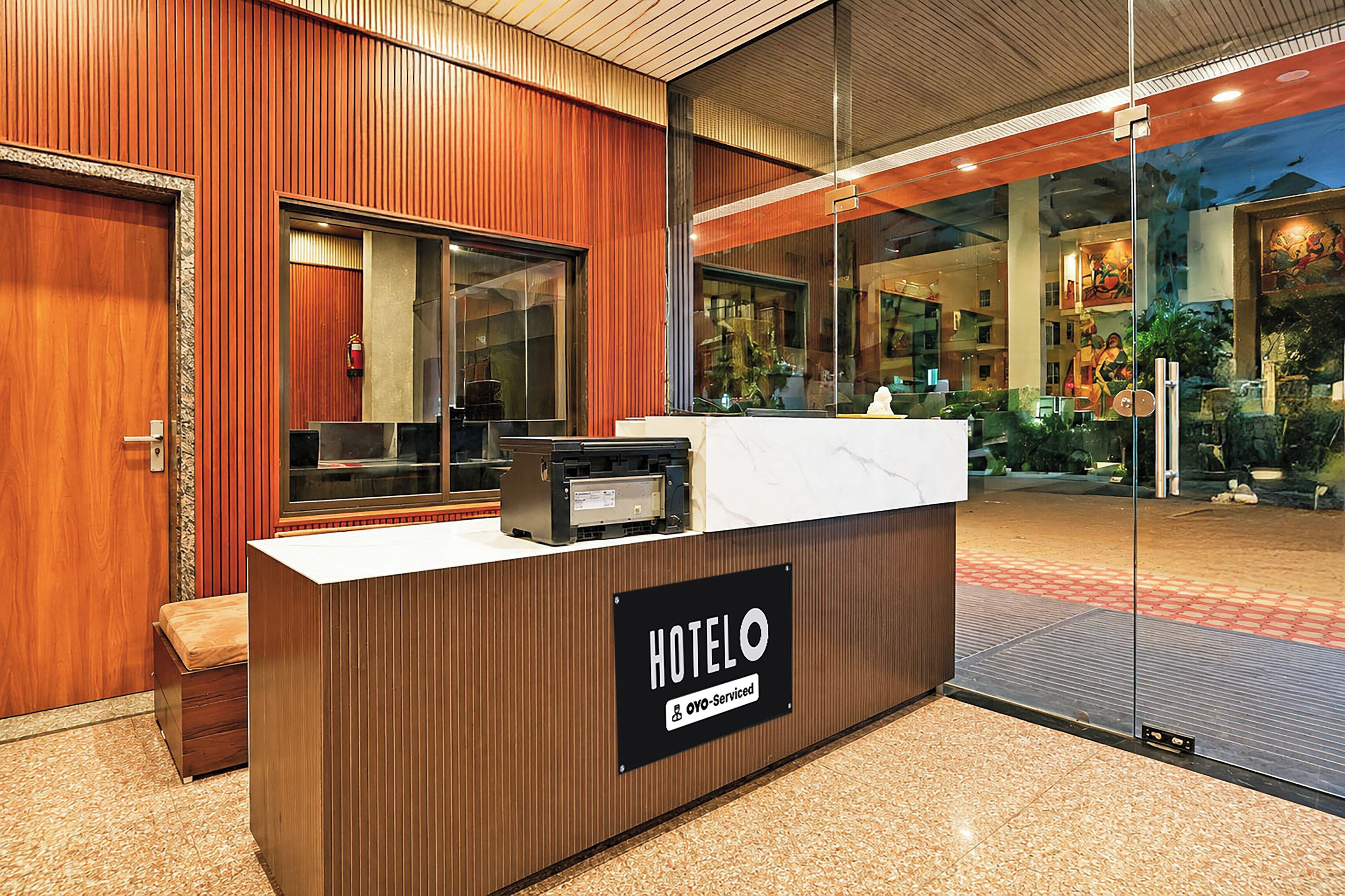 A hotel reception desk with a sign indicating it is serviced by OYO.