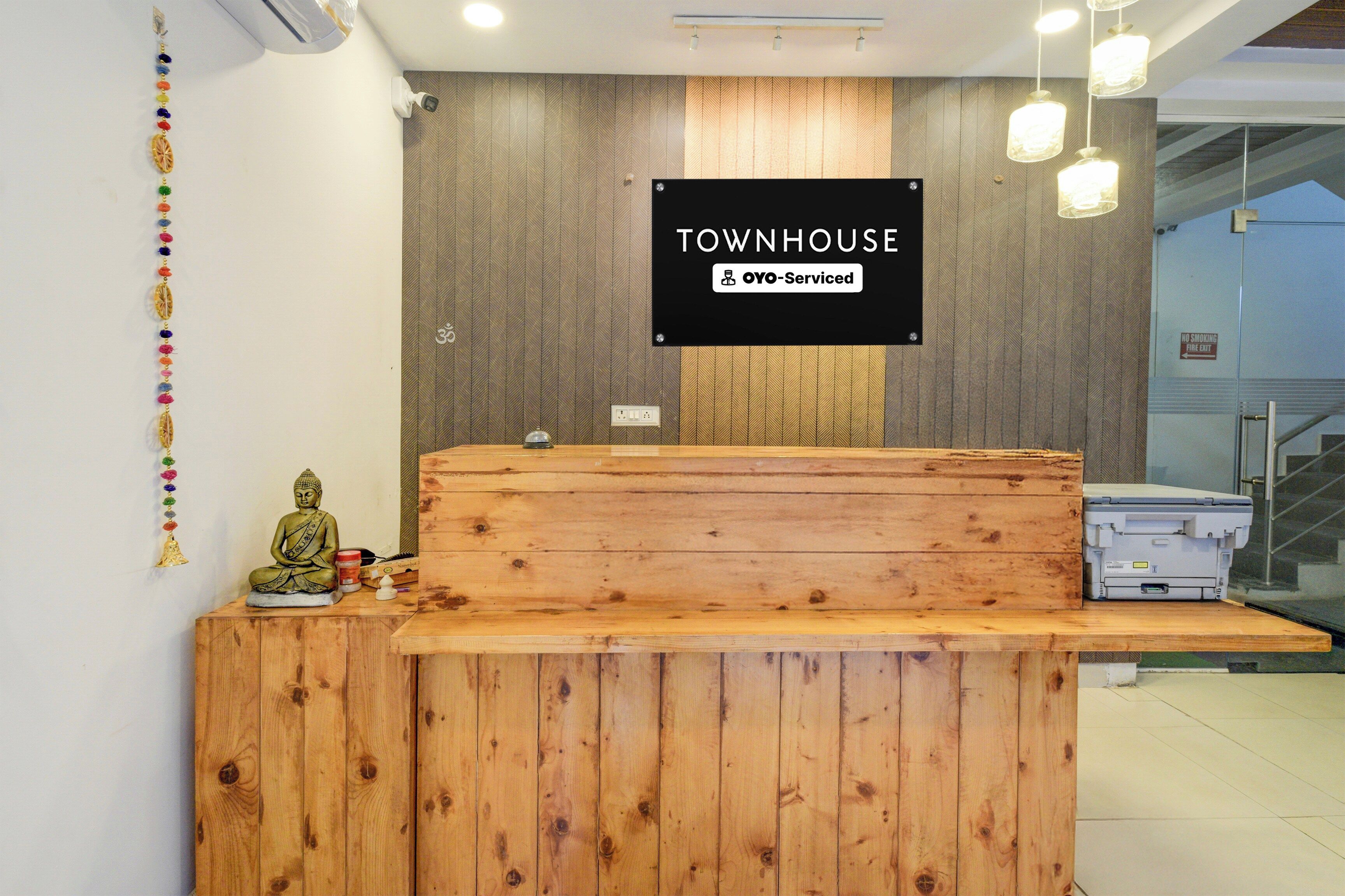 A reception desk with a sign reading 'TOWNHOUSE' and 'OYO-Serviced'.